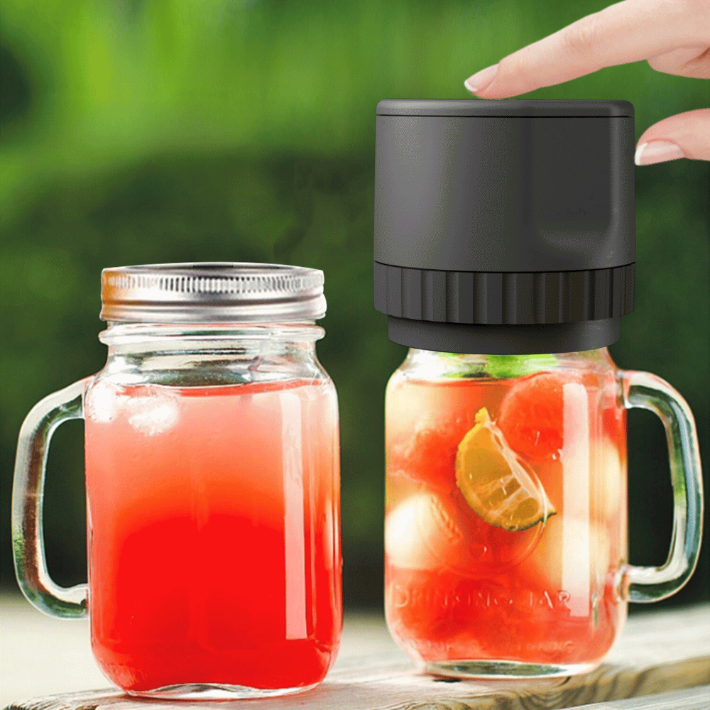 Black vacuum jar sealer sealing two mason jars with fruit beverages outdoors.
