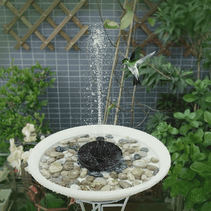 Solar water fountain pump running in a garden birdbath surrounded by decorative stones