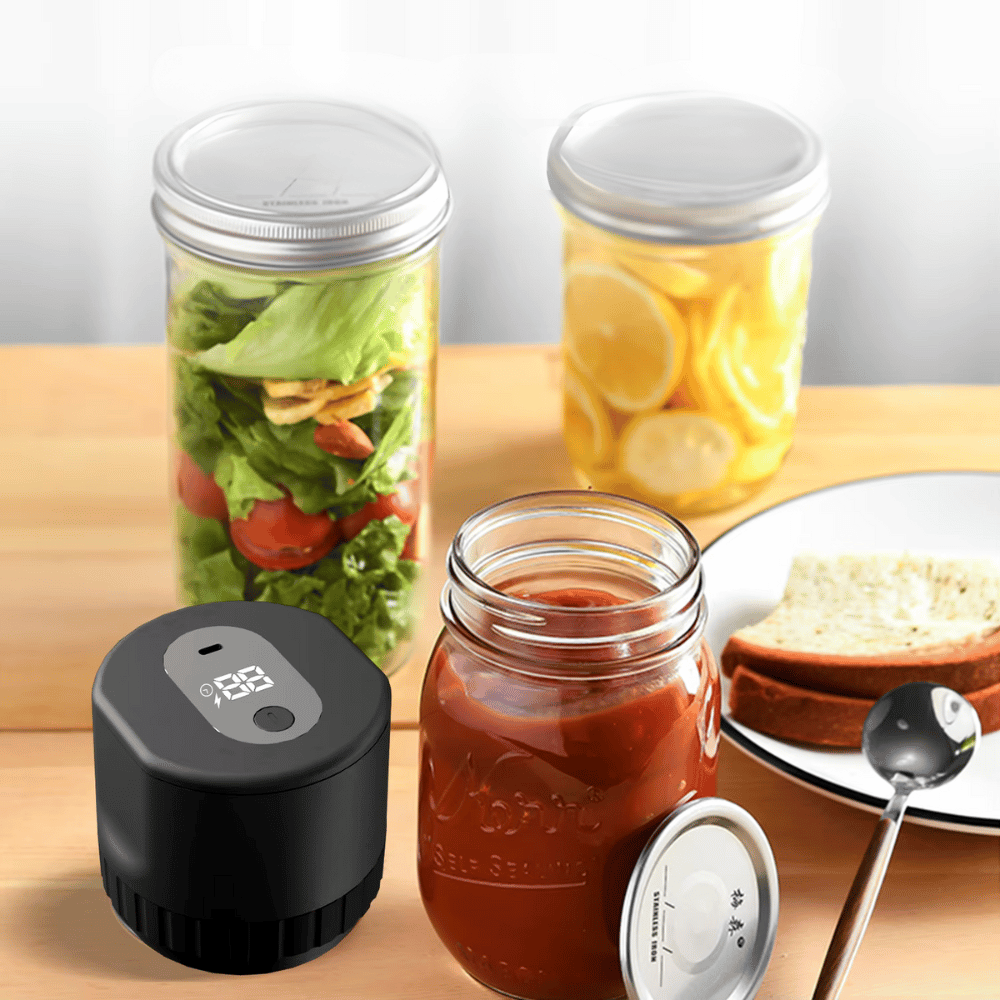 Electric vacuum sealer shown preserving jars of salad, sauce, and pickles on a kitchen counter.